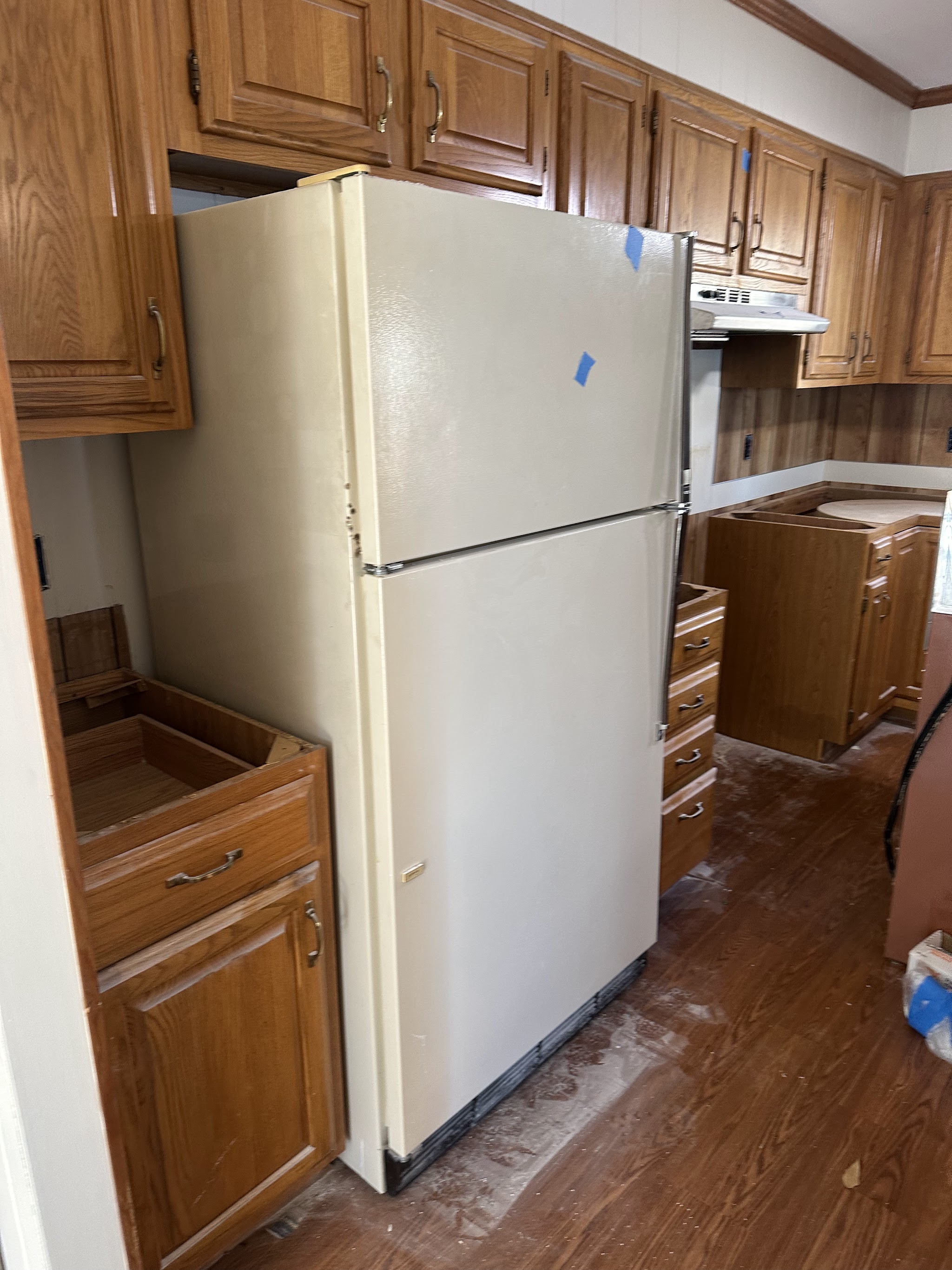 A fridge in a stripped kitchen waiting for pickup